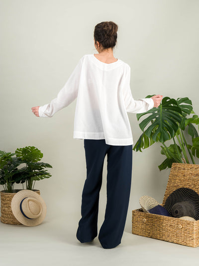 chemise blanche évasée en popeline de coton blanc avec des manches longues pour un look casual chic porté avec un pantalon à pont bleu marine chic col rond