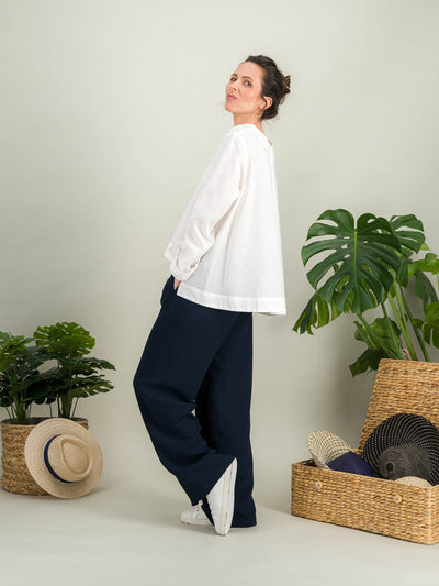 chemise blanche évasée en popeline de coton blanc avec des manches longues pour un look casual chic plus longues dérrière porté avec un pantalon bleu marine